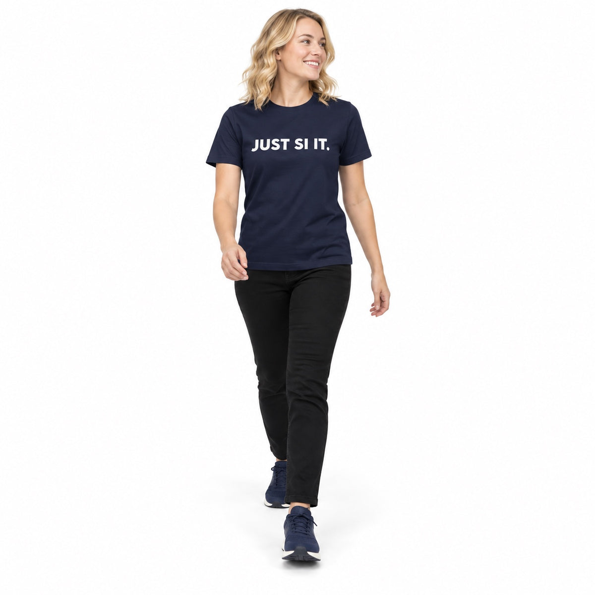 Full-body blonde woman wearing the navy JUST SI IT. t-shirt with white chest lettering and navy trainers, stepping forward on a white background.
