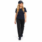 Full-body blonde model wearing the dark navy MAKE NO MISTAKES. embroidered cap with a matching navy T-shirt and shoes, stepping forward on a white background.