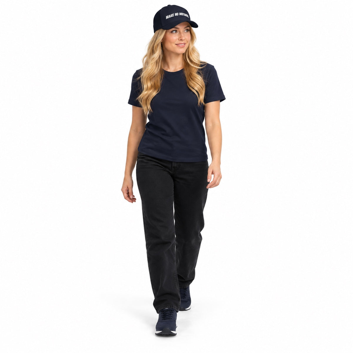 Full-body blonde model wearing the dark navy MAKE NO MISTAKES. embroidered cap with a matching navy T-shirt and shoes, stepping forward on a white background.