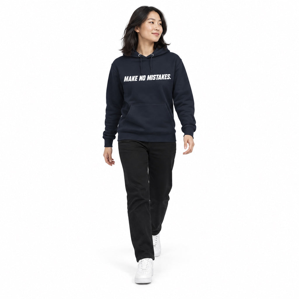 Full-body model wearing the navy blazer MAKE NO MISTAKES. hoodie with white chest print, stepping forward with relaxed arms on a plain white background.