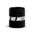 Front view of the black 11 oz MAKE NO MISTAKES. ceramic mug with bold white lettering and a glossy finish.