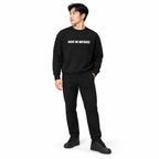 Full-body model wearing the black MAKE NO MISTAKES. sweatshirt with white chest print, black trousers and trainers, looking to the side on a white background.