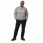 Full-body man wearing the carbon grey MAKE NO MISTAKES. sweatshirt with white chest print and black trainers, hands in trouser pockets on a white background.