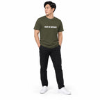 Full-body model wearing the military green MAKE NO MISTAKES. T-shirt with white chest print, standing with both hands in pockets and looking aside on a white background.