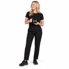 Full-body blonde model in black clothing holding the glossy black Super Intelligence mug with white two-line lettering facing forward, looking aside on a plain white background.