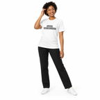 Full-body model wearing the white Super Intelligence T-shirt with the front graphic visible, posing with one hand touching the hair on a plain white background.